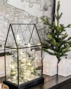 A glass case with lights and christmas trees in it.